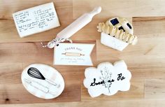 some cookies are sitting on a table with writing and cookie cutters next to them