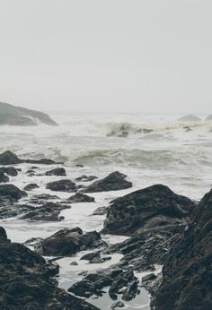 a person standing on rocks near the ocean