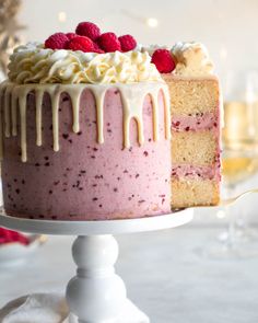 a close up of a cake on a plate with raspberries and icing