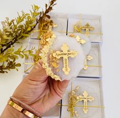 a person holding a cross in their hand next to some boxes with gold crosses on them