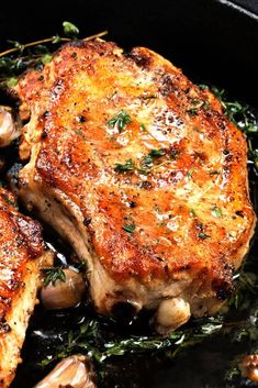 two pieces of meat in a skillet with mushrooms and herbs on the side, ready to be cooked