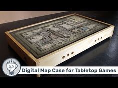 a wooden box sitting on top of a table with a map in it's center