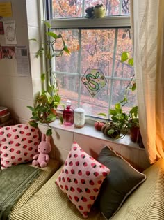 a window sill filled with pillows and plants