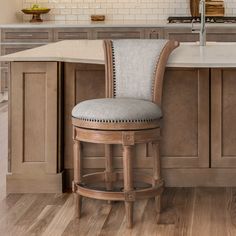 a kitchen with an island and bar stools in front of the countertop area