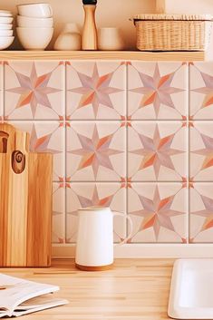 a wooden cutting board sitting on top of a kitchen counter next to a white plate