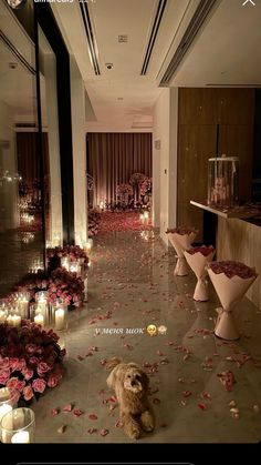 a dog is sitting on the floor in front of flowers and candles at a wedding