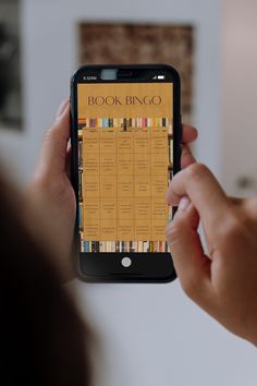 a person holding an iphone with a book bingo on the screen