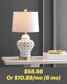 a white table with a lamp on it and a price tag for the lamp is $ 699