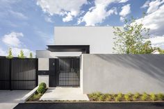 a white house with a black gate in front of it