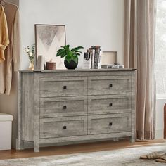 a dresser with drawers and a potted plant on top