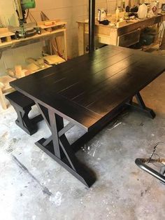 a wooden table sitting in a garage next to tools