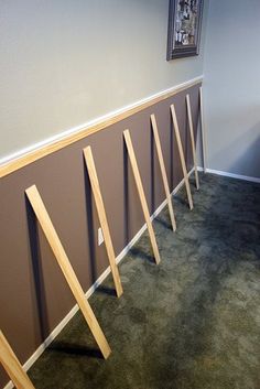 a room with several wooden poles on the wall and carpeted flooring in front of it