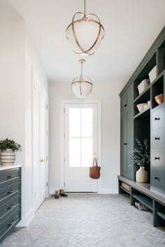 a room with white walls and gray cabinets, an entryway to the bedroom is shown