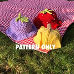 three knitted hats sitting on top of a red and white checkered tablecloth