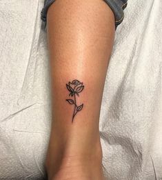 a woman's foot with a small rose tattoo on the left side of her leg