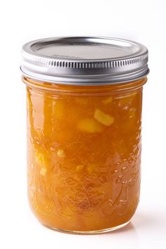 a glass jar filled with pickles on top of a white table