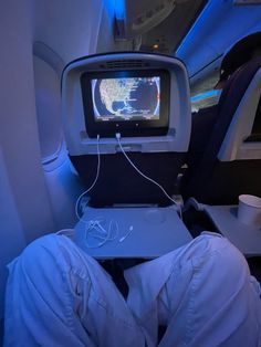 a person sitting in an airplane watching tv