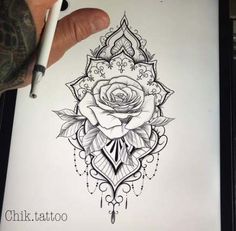 a drawing of a rose on paper with a pen in it's left hand