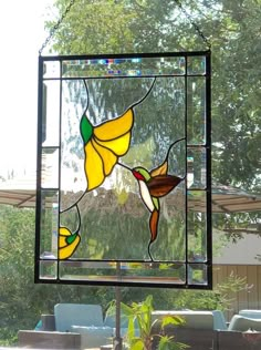 a stained glass window hanging from the side of a tree