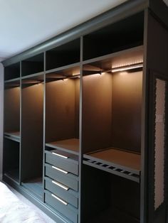 an empty walk in closet with drawers and lights