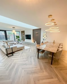 a living room filled with furniture and a wooden floor covered in hard wood planks