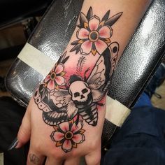 a hand with a skull and flowers on it