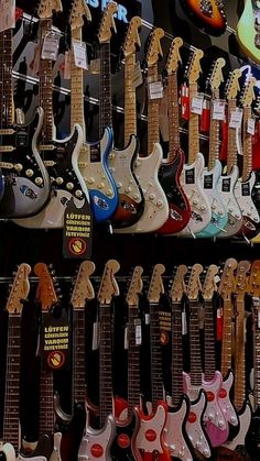 many guitars are on display in a store