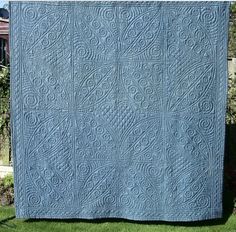 a blue quilt sitting on top of a wooden fence