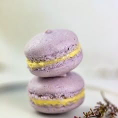 two purple macaroons stacked on top of each other next to some lavender flowers