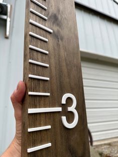 a person holding up a wooden sign with numbers on it