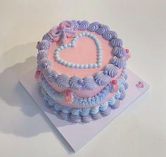 a heart shaped cake sitting on top of a white table next to a pink napkin