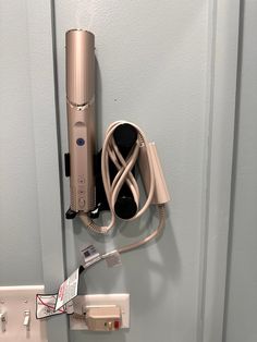 the hair dryer is plugged in to the wall next to the charger