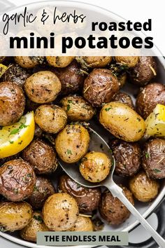 a white bowl filled with roasted mini potatoes and lemon wedges, topped with parsley