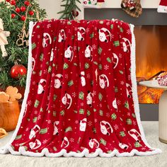 a red christmas blanket sitting next to a fire place