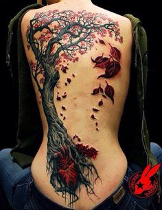 the back of a woman's body with red flowers on it and leaves falling off