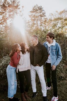 three people are standing together in the woods