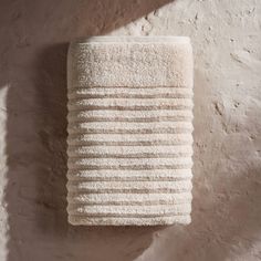 a white towel hanging on the side of a wall