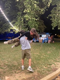 a man carrying a woman on his back in a park