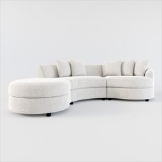 a curved sectional sofa with pillows on the top and bottom, sitting in front of a white background