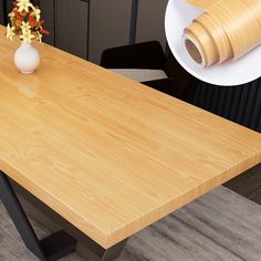 a wooden table with some flowers on it and a roll of tape next to it