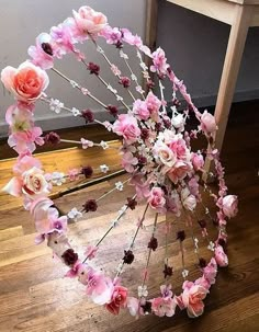 an umbrella made out of flowers sitting on top of a wooden floor