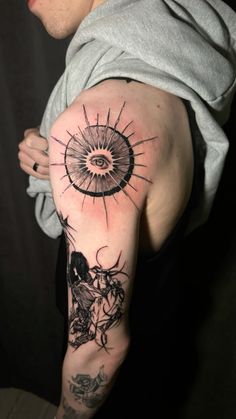 a man's arm with tattoos on it and an eye in the sky above him