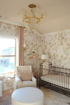 a baby's room with a crib, rocking chair and chandelier