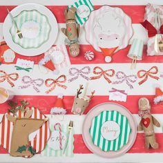 a table set for christmas dinner with plates, napkins and utensils on it