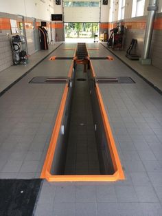 an empty gym with rows of benches in the middle and orange lines on the floor