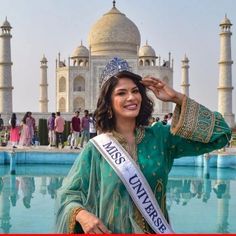 a woman wearing a tiara standing in front of a pool