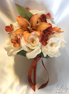 a bridal bouquet with white roses and orange lilies on a satin - covered background