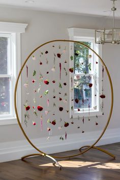 a circle with flowers hanging from it in front of a window