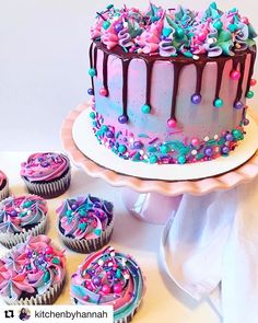 there is a cake and cupcakes on the table next to each other with sprinkles