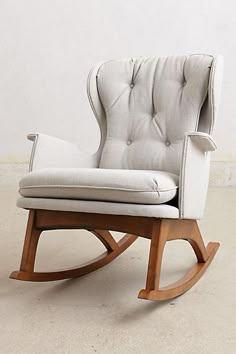 a white rocking chair sitting on top of a hard wood floor